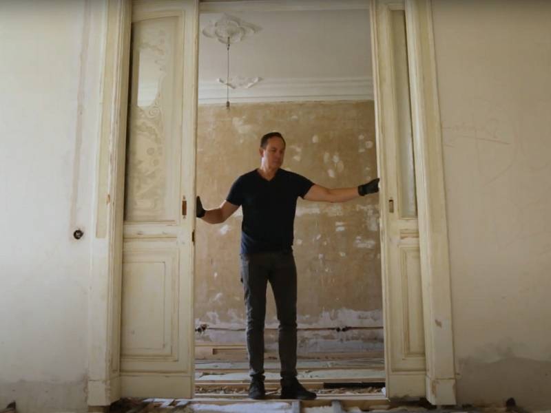 Schauspieler Moritz Lindbergh öffnet die hohen Schiebetüren seiner Berliner Altbauwohnung.